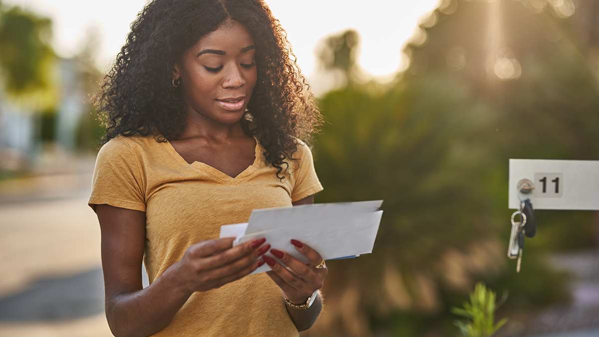 Viral Hepatitis Notification After Exposure Thumbnail A woman standing in front of her mailbox checking her mail