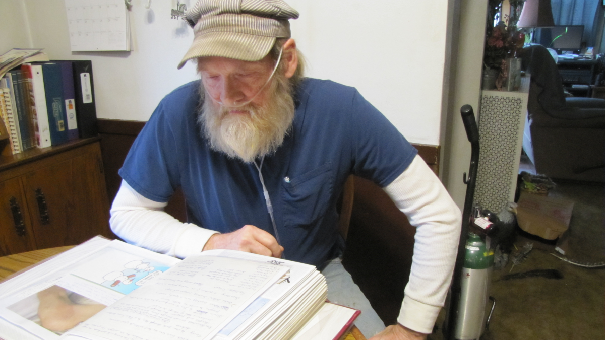 man with oxygen tank sitting at a table