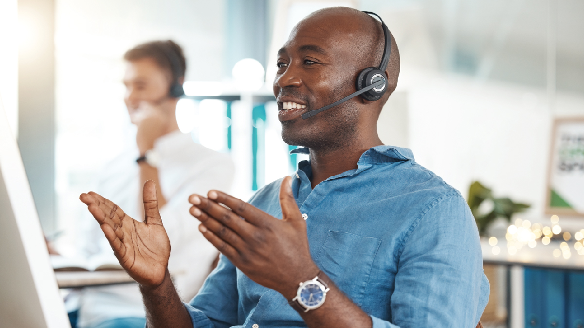 Hotline Call Center Picture of young, African American man at a computer with a phone headset on.