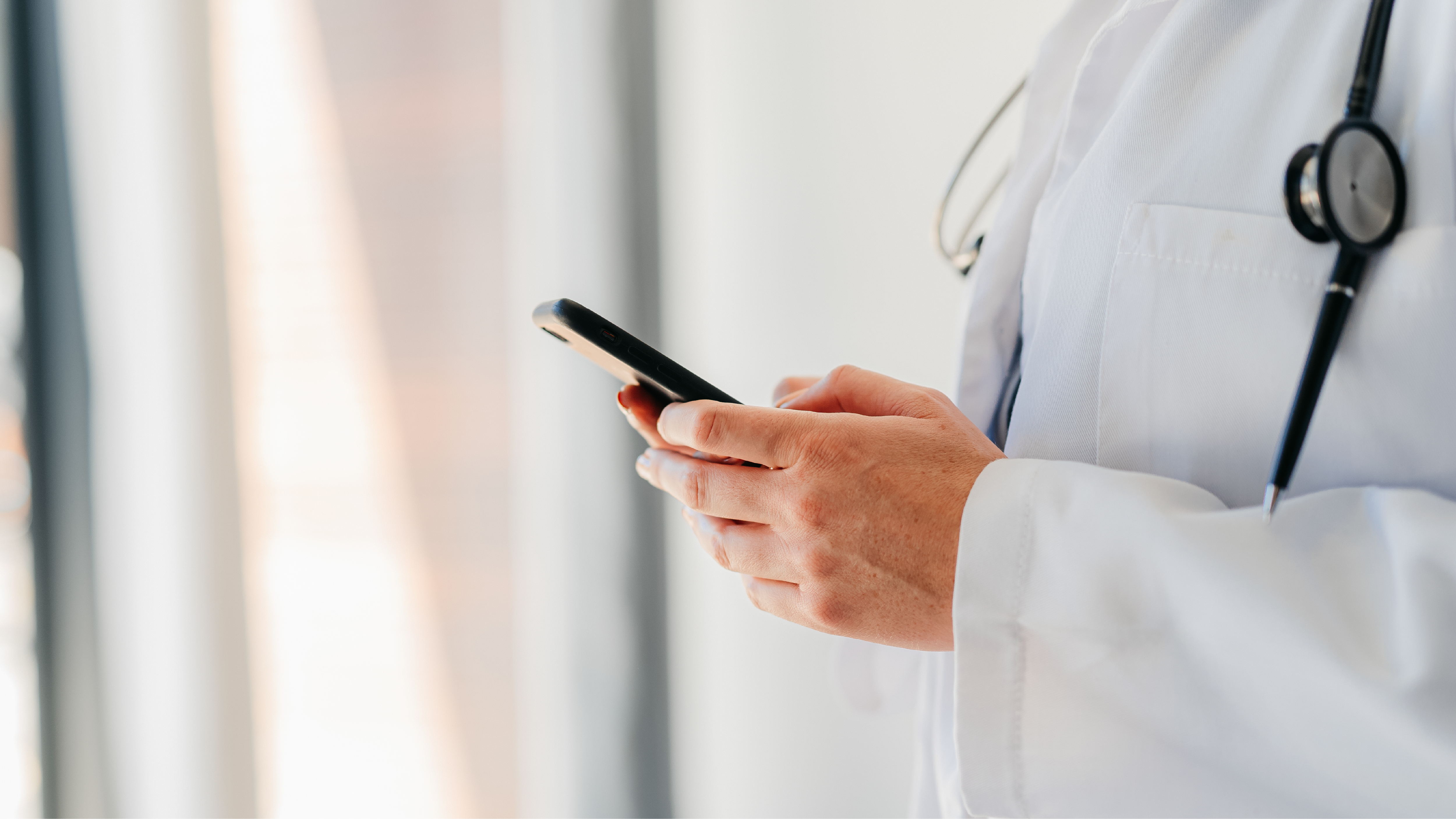 Thumbnail for Partner Services A health care provider with a stethoscope typing on a smart phone.