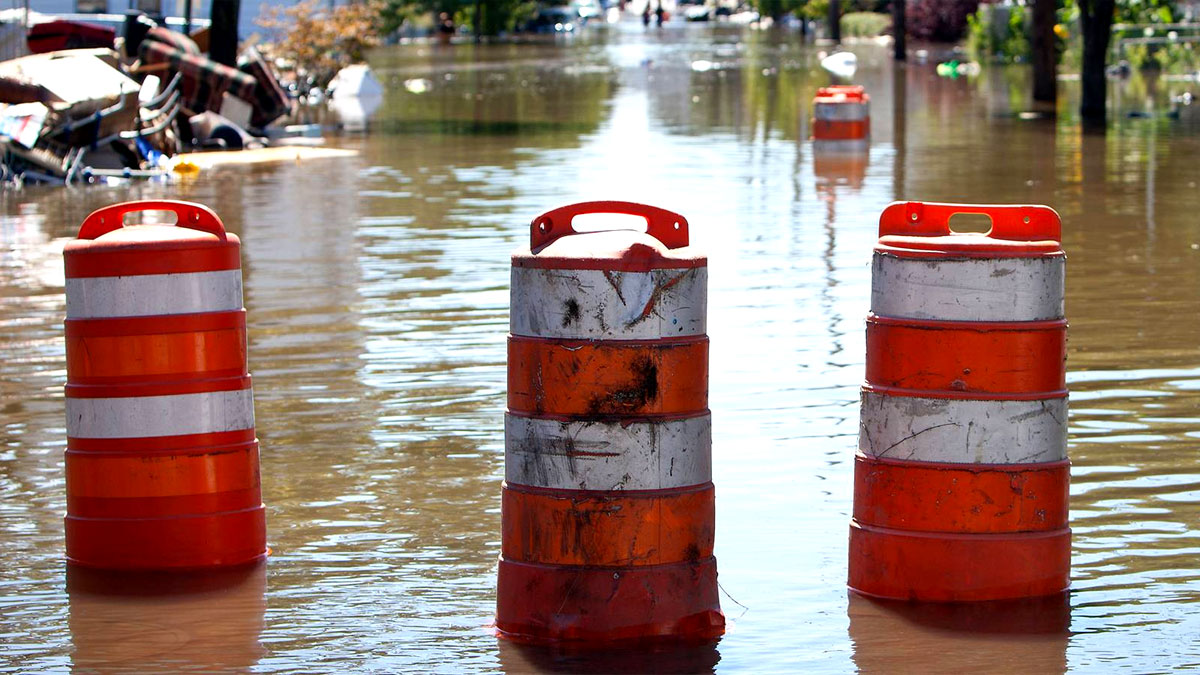 — title missing — Orange barrels blocking a flooded road