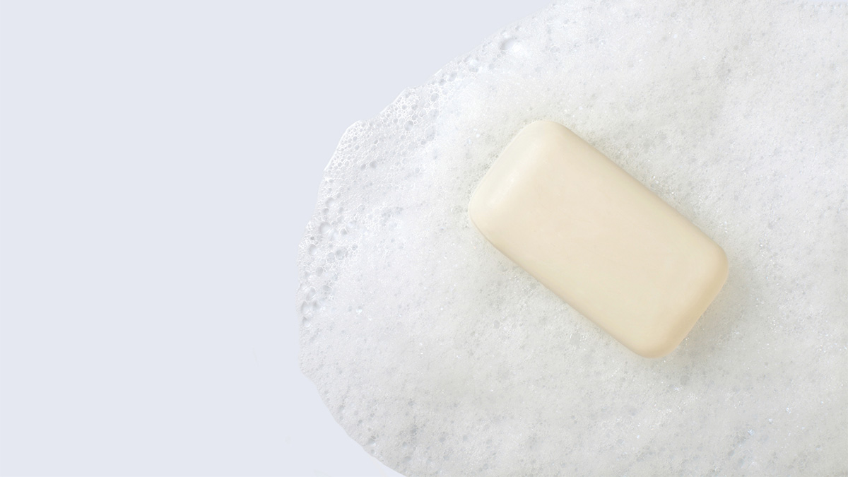 GettyImages-1307713077-1200px A bar of soap with soap suds on a white surface