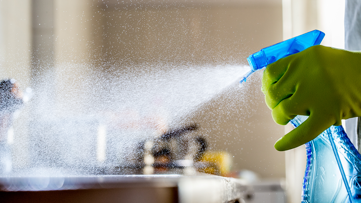 Person spraying cleaner onto a counter Person spraying cleaner onto a counter