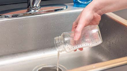 clean-feeding-items-2 Discarding leftover milk from bottle into the sink.