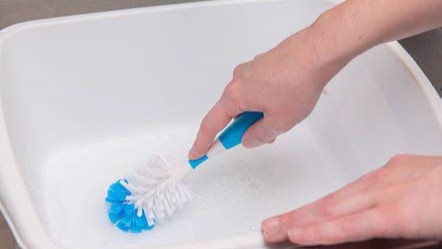 clean-feeding-items-6 A person cleaning a wash basin.