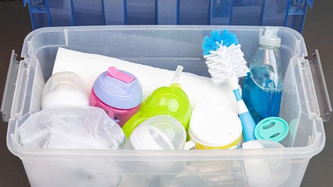 — title missing — A container full of cleaning supplies and infant feeding items.