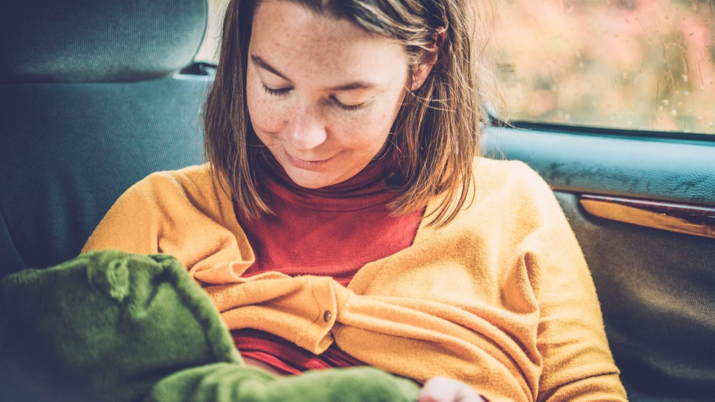 Breastfeeding in a car Mother breastfeeding her baby in a car.