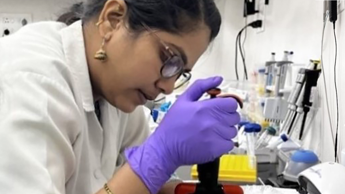 Using Whole Genome Sequencing in India to Combat Antimicrobial Resistance Threats - Page Thumb Woman looking into a microscope in a lab in India