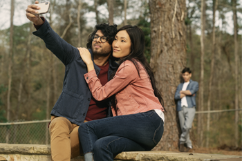 preventingstalking350x233 Couple taking a picture while a man watches in the background.