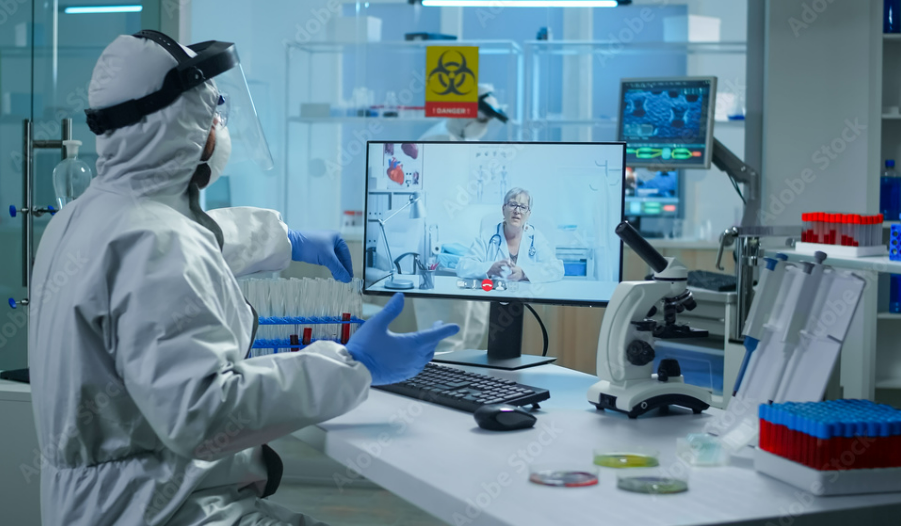 CDC Partners Public health lab worker in personal protective equipment on a video call with a healthcare provider