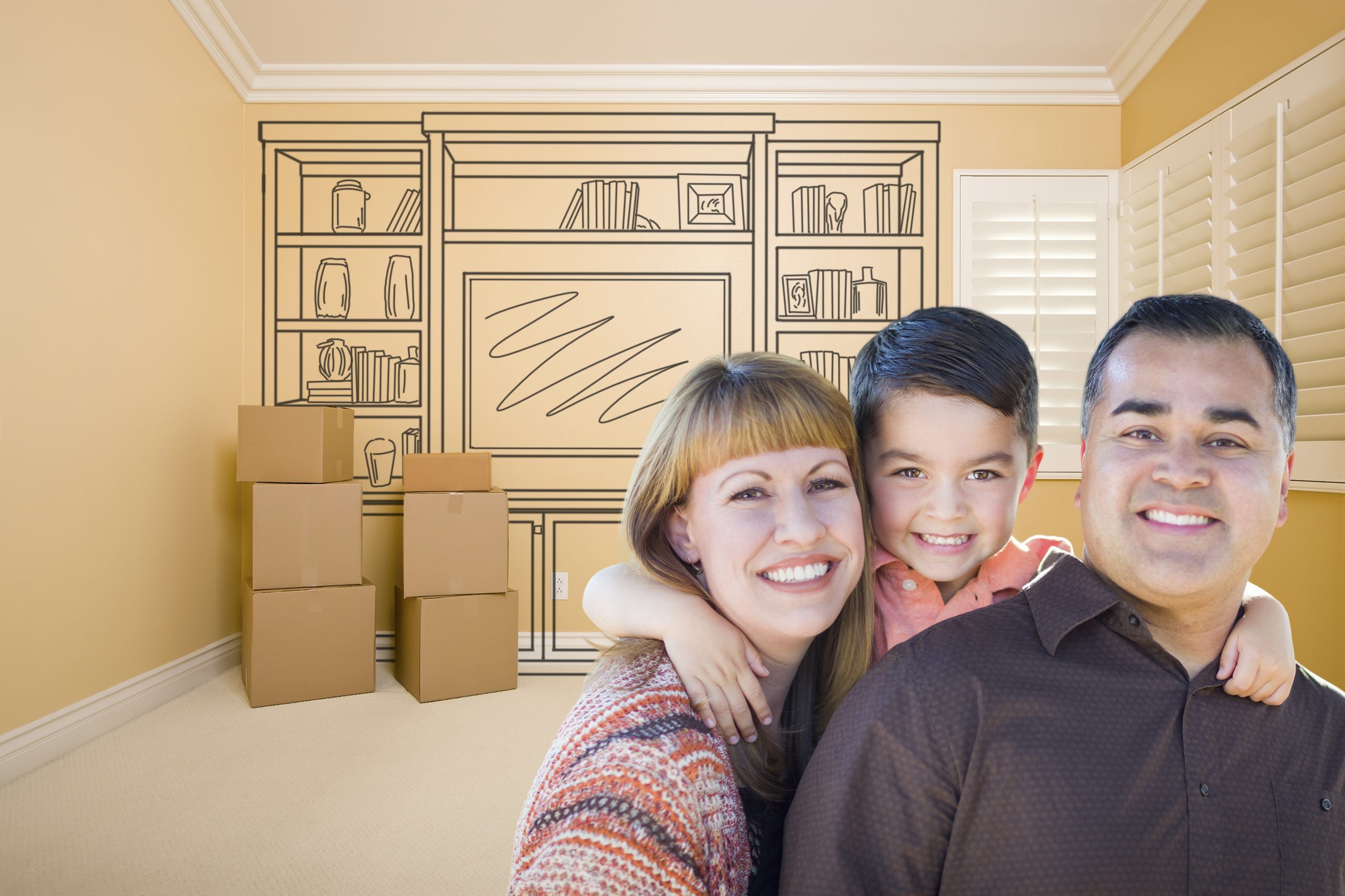 A man and a woman with a young boy A woman, young boy and a man with moving boxes and a drawing of furniture in the background.