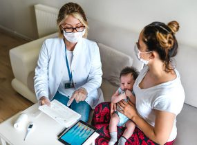 -- title missing -- Female doctor consults with mother and child.