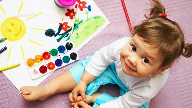 girl-w-paint-set Girl looking at camera playing with a paint set.