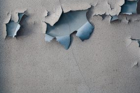 Peeling paint Blue paint peeling from a gray wall