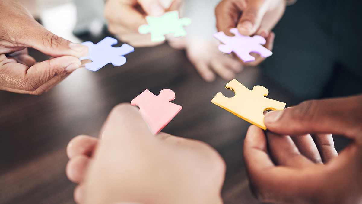 Health Disparities in Legionnaires Disease Group of diverse people around a table each holding a puzzle piece.