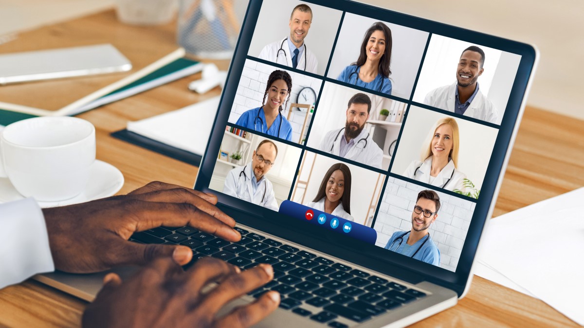 Virtual Meeting A person typing on his laptop while watching a virtual meeting