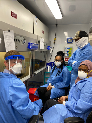 stephen-lavoie Laboratory staff wearing scrubs and other personal protective equipment pose for photo in lab.
