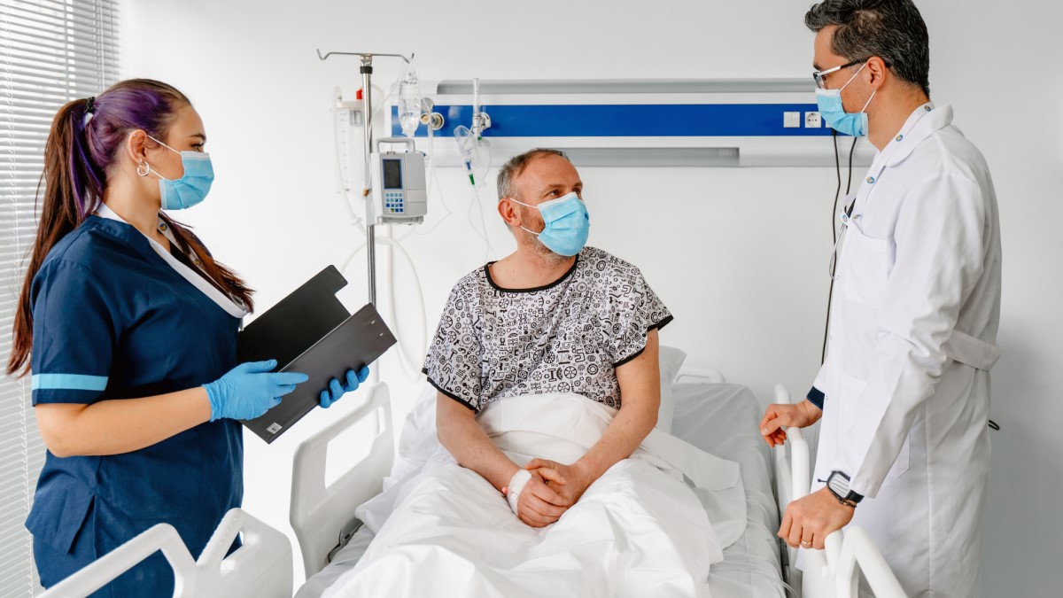Man Hospital a man in a hospital talking to his doctor and nurse