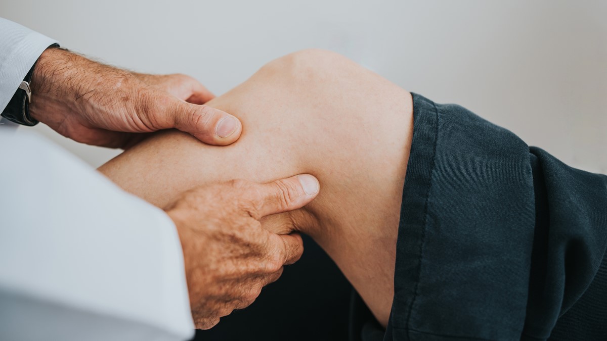 HCP examining patient knee HCP examines a patient's arthritic knee.