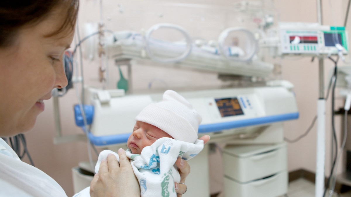 Woman and preterm baby Woman holding preterm infant in a hospital setting