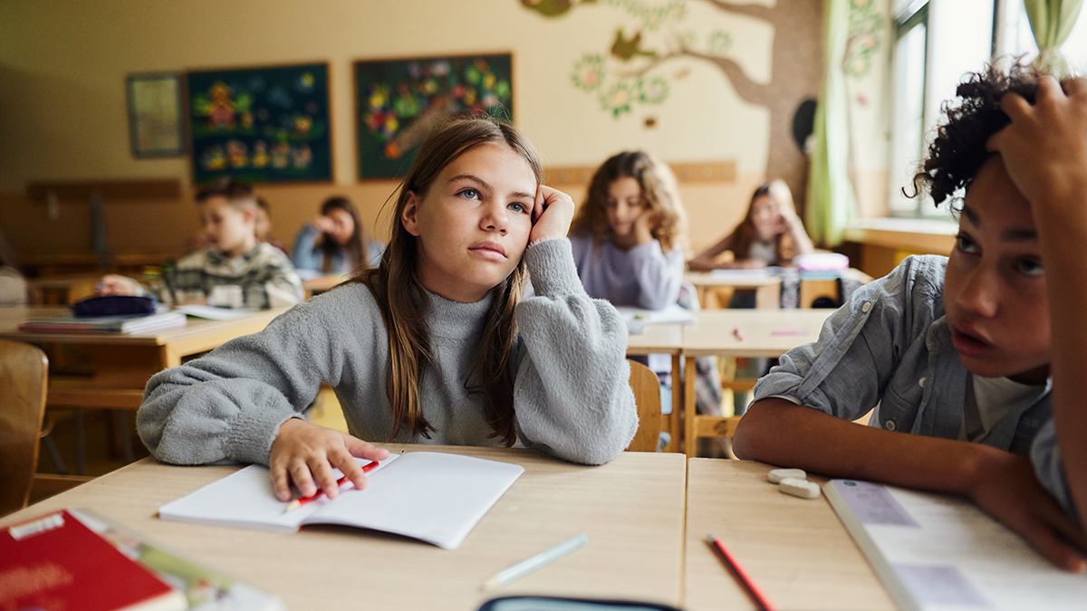 ME/CFS in Children Tired schoolgirl attending a class with her classmates at elementary school.