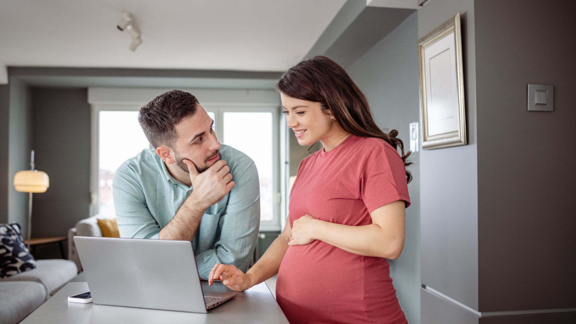 Expectant couple looking at computer Expectant couple looking for information on a laptop