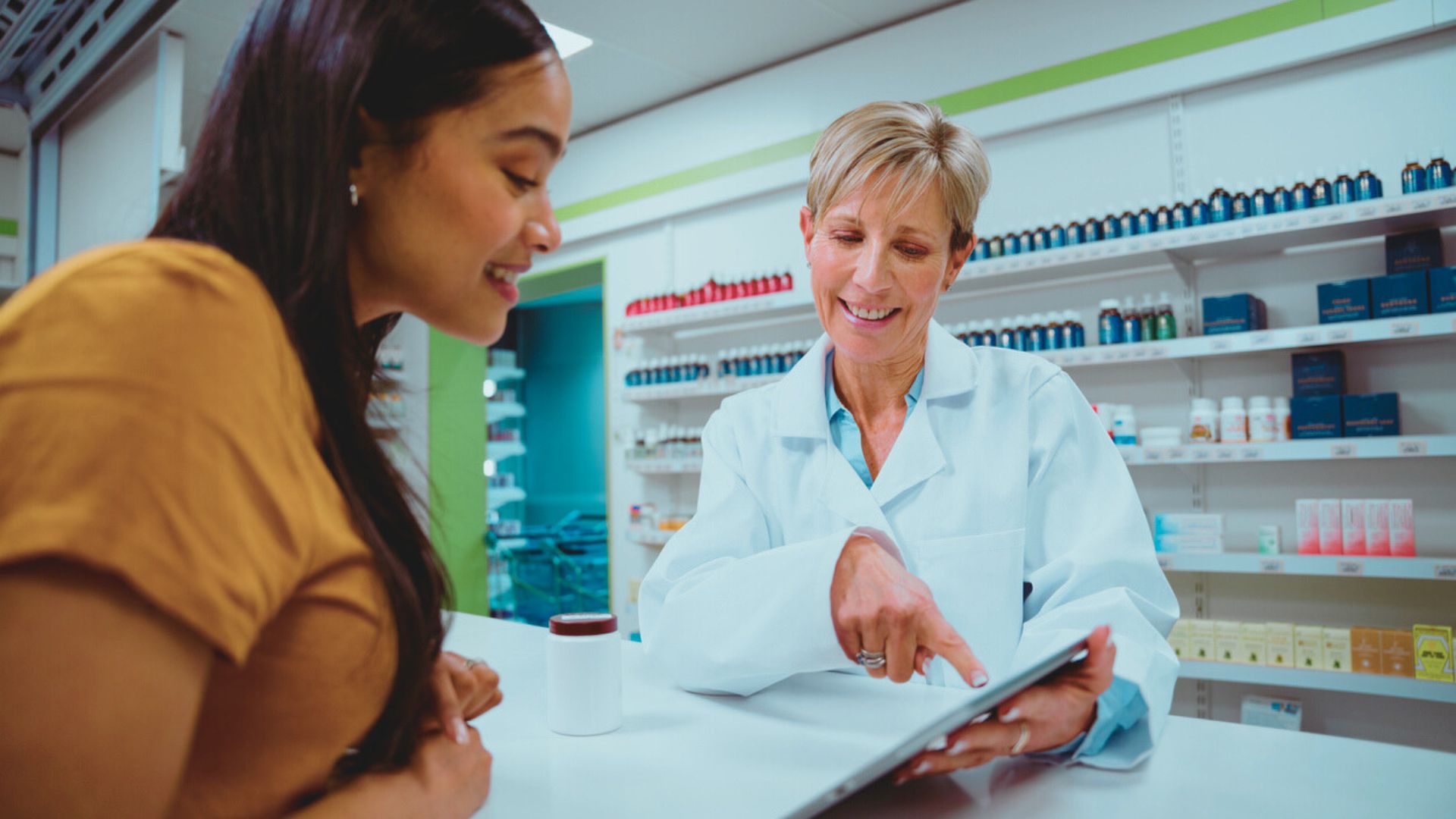 — title missing — Woman talking with a pharmacist about medication use