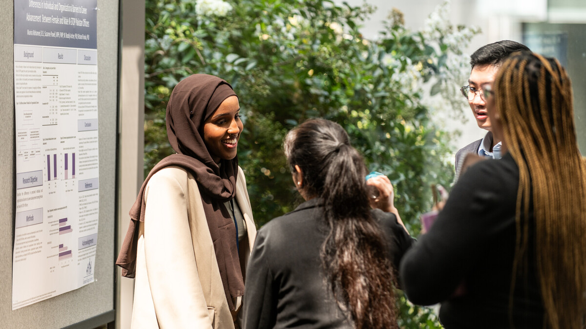 student programs Student wearing a hijab discussing her project at CDC Student Showcase.