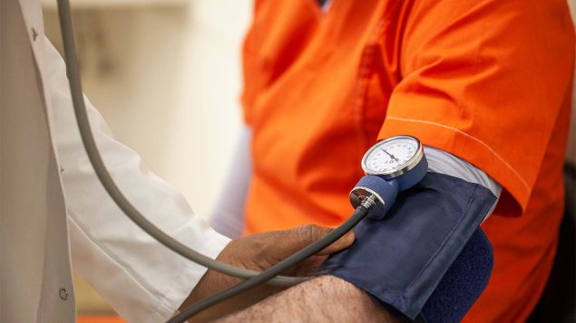 Emergency Department Visits by Incarcerated Adults for Nonfatal Injuries — United States, 2010–2019 The figure is a photo of a health care provider checking a person’s blood pressure.