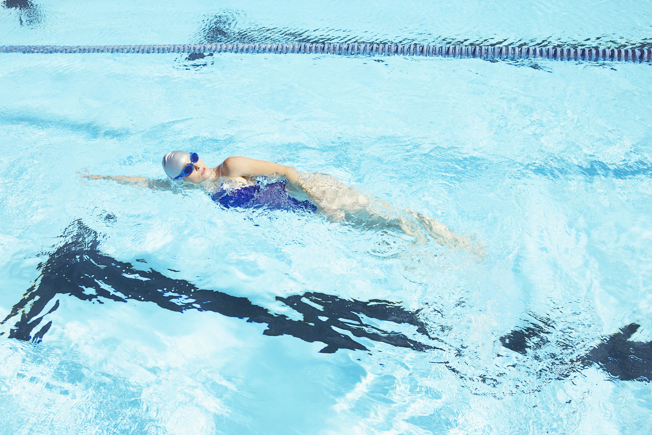 Woman swimming laps in pool Woman swimming laps in public pool.