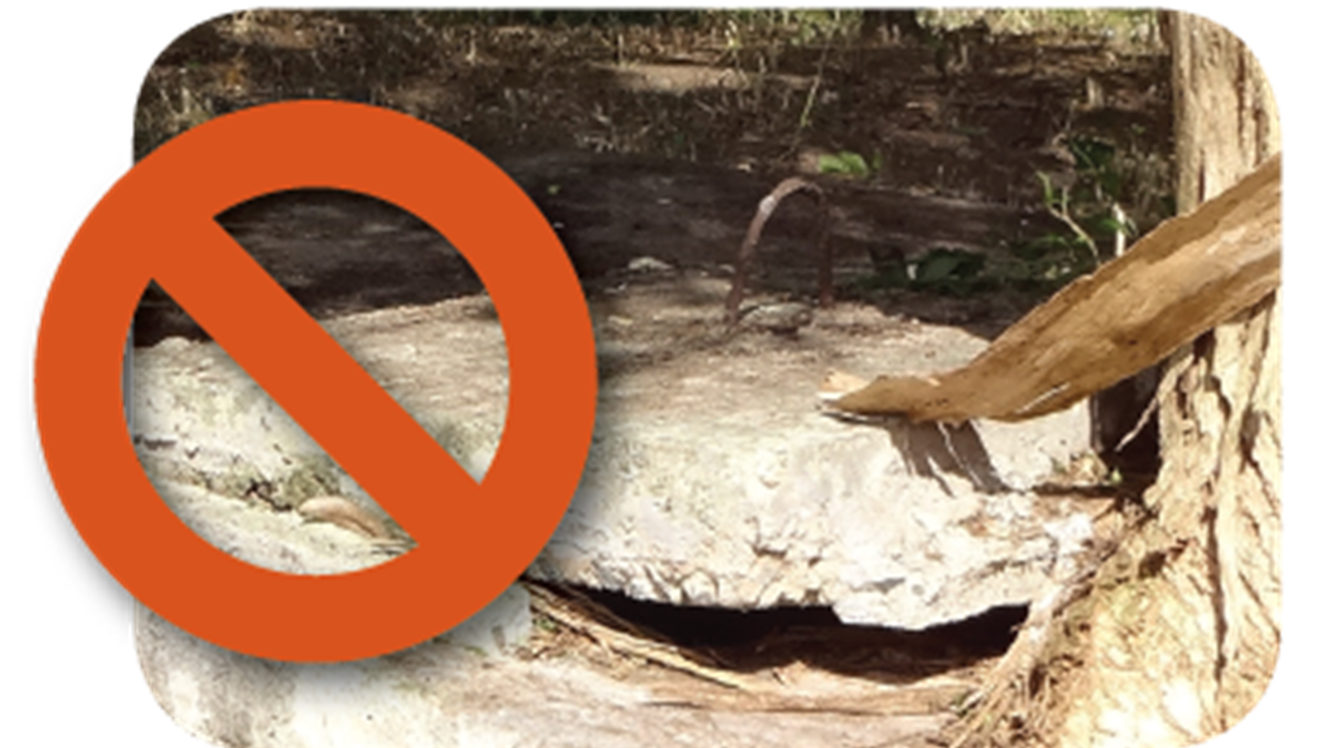 — title missing — A broken cement septic tank cover with a "no" symbol.