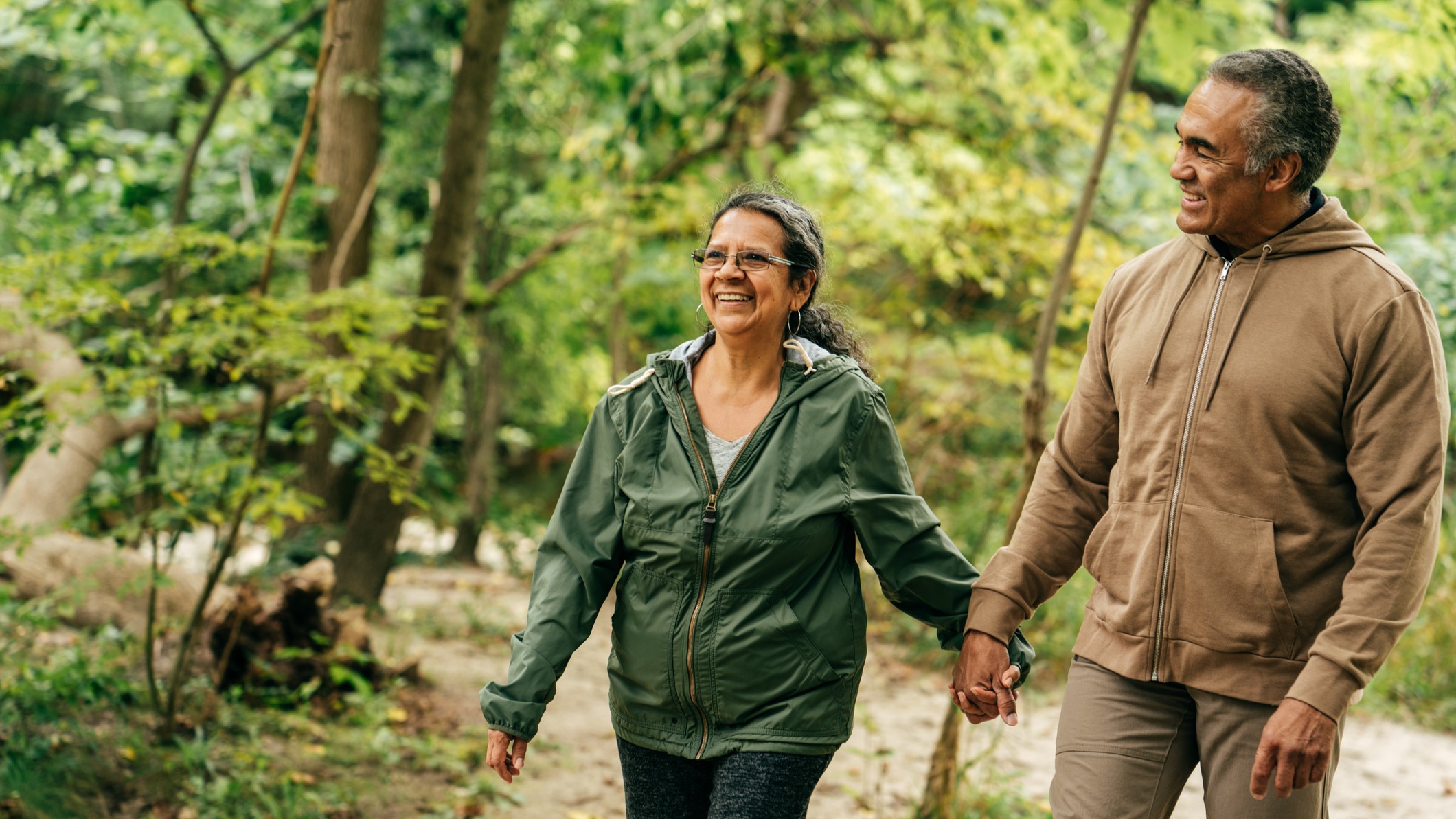 Older Couple Hiking _16-9_2 Older couple holding hands and taking a walk outside.