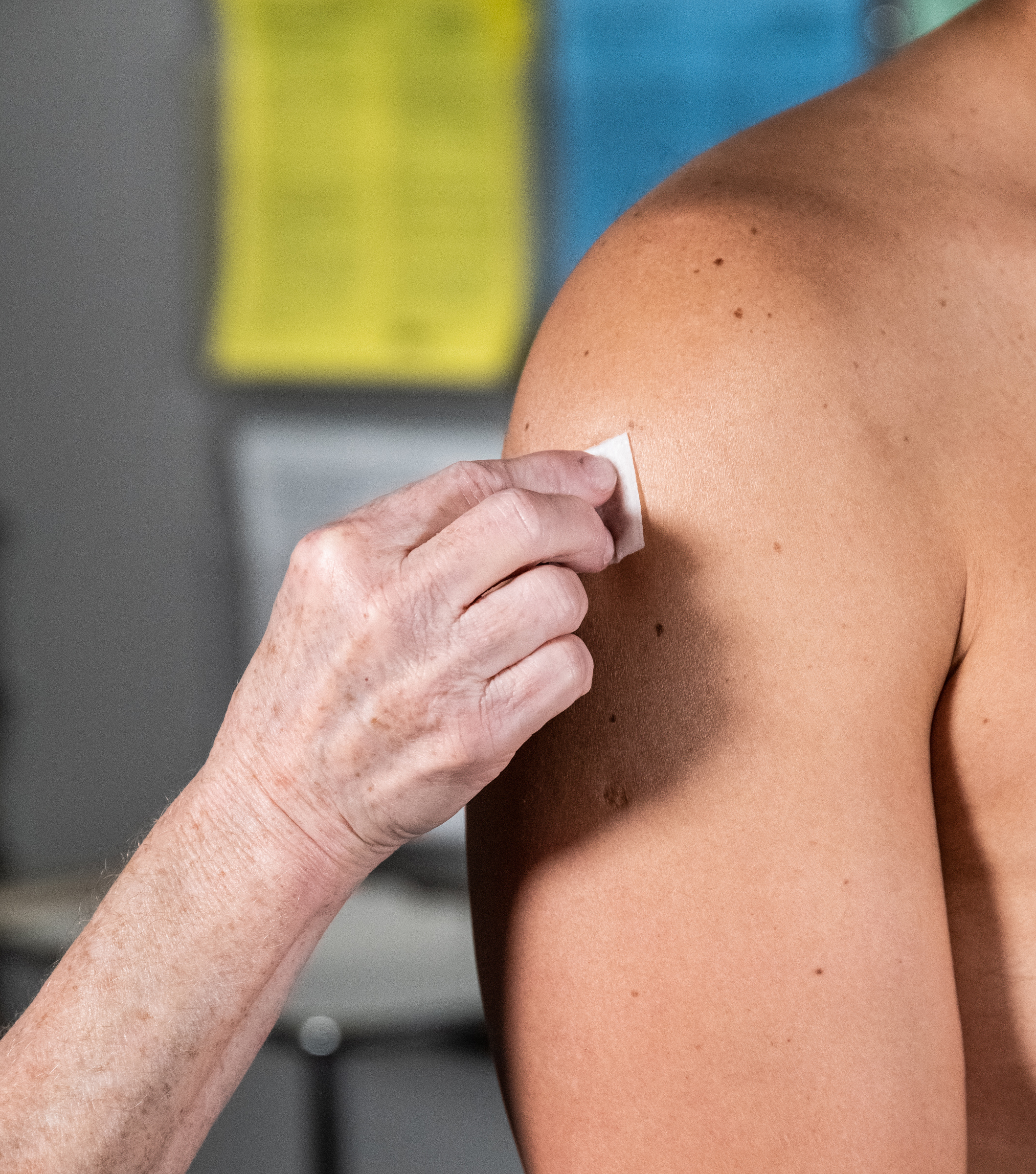 Mpox Injection Site 1 Image of a hand cleaning a light-skinned person's upper arm in preparation for vaccination.
