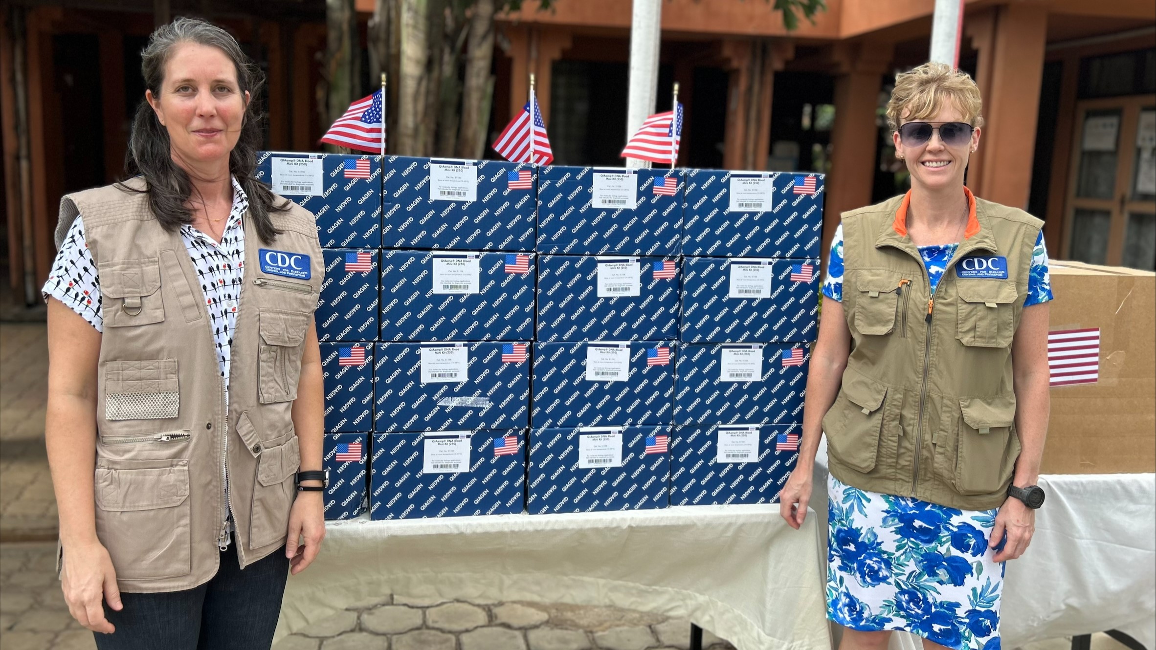 CDC staff stand by a table covered in boxes, which contain laboratory testing supplies for mpox