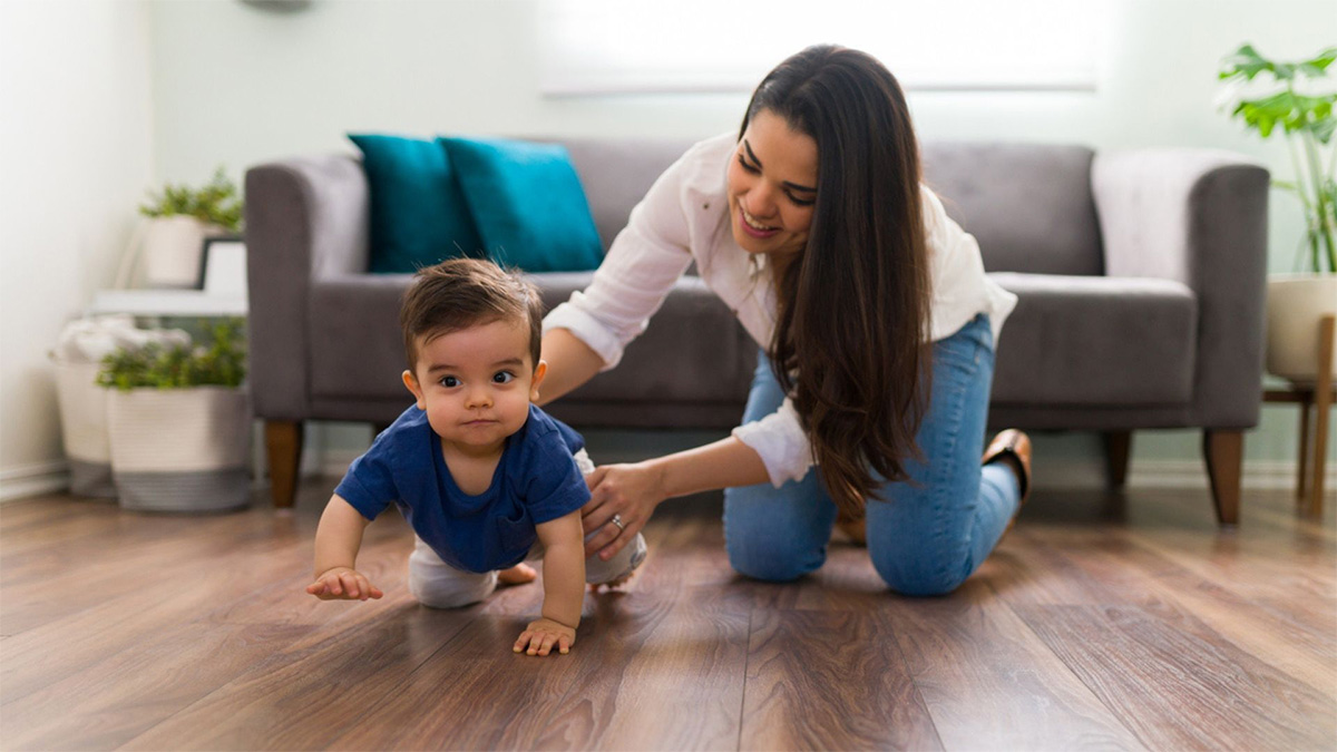 Baby learning to crawl A mom helps her child crawl