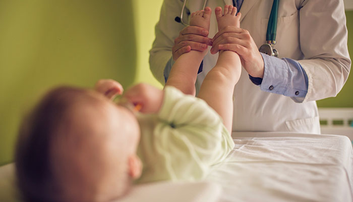 Doctor testing infant's reflexes Doctor testing infant's reflexes