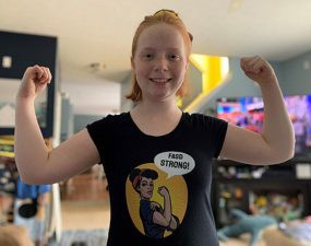 specialfeature02 Brenna as a teen wearing a “We Can Do It!” parody shirt that says “FASD Strong!”