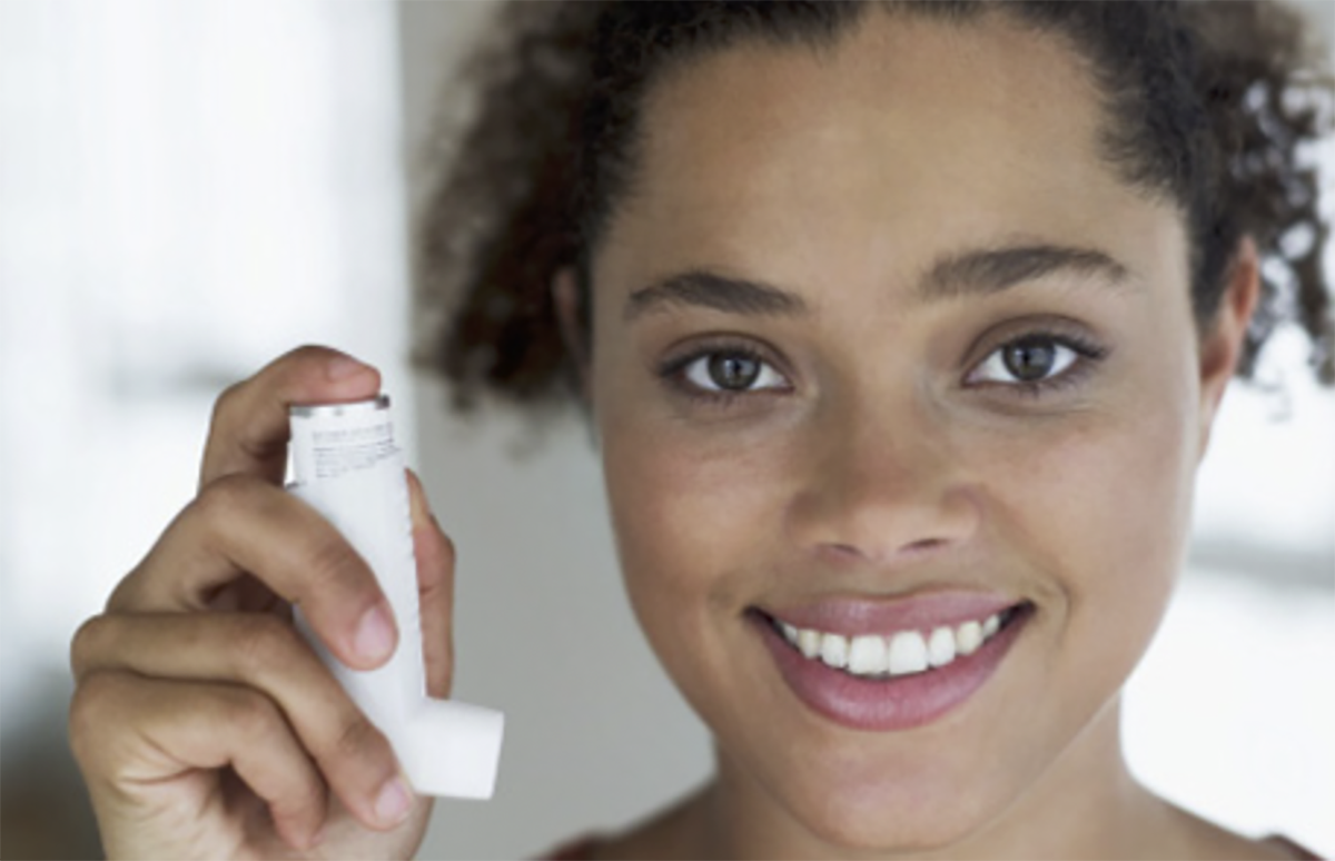 cdcwork01 Young woman holding an inhaler in her right hand.