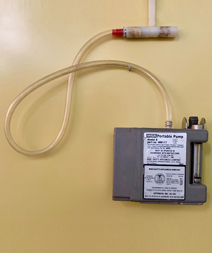 outofcollection02 The pump has a long clear plastic tube sticking out of it that connects to a white plastic clip that would be attached to a shirt lapel. The air samples are pumped in through this tube to the sample container.