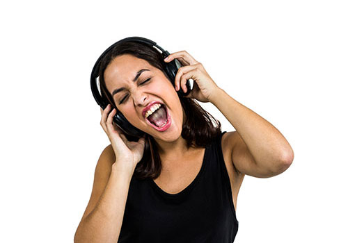 intro01 Woman wearing headphones and singing. Her hands are on each earpiece.