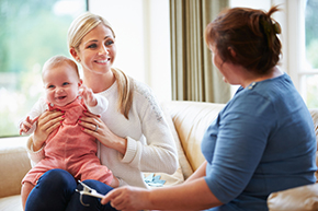 Health Visitor Talking To Mother With Young Baby Health Visitor Talking To Mother With Young Baby