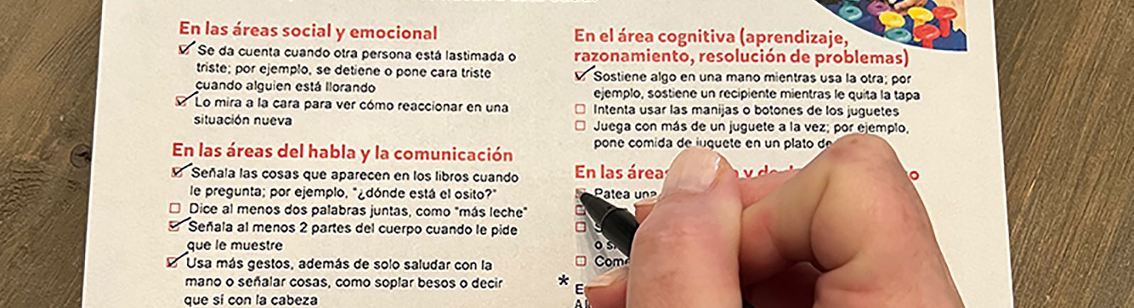Una mujer completa una lista de un niño de dos años de edad.