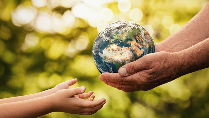 Climate and health Senior hands giving small planet earth to a child