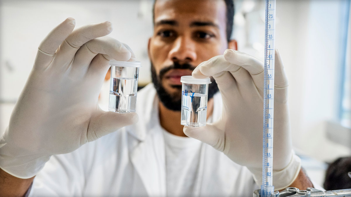Photo of a microbiologist comparing vials of fluids