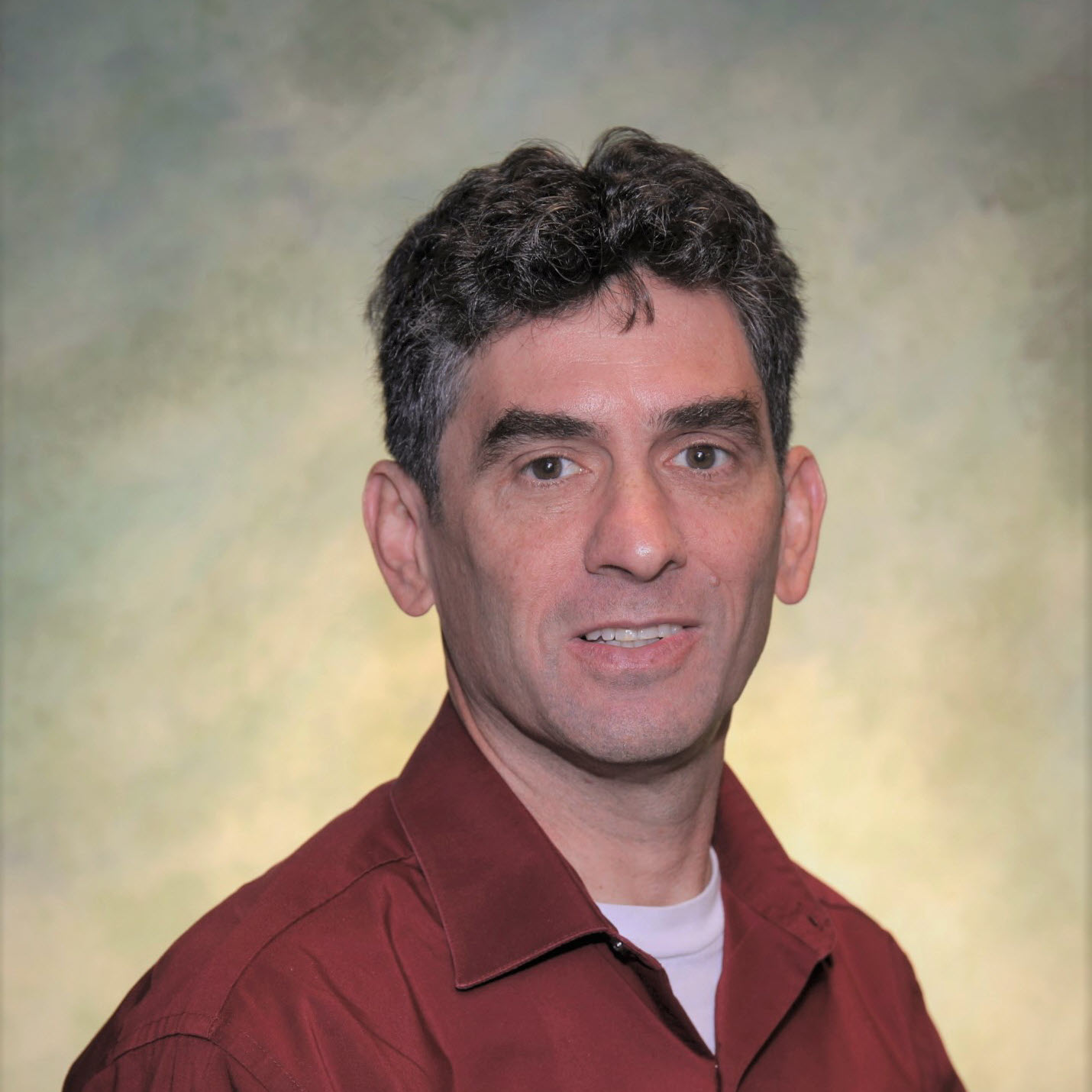 Alan_Simon_Square A smiling man wearing red buttoned shirt.