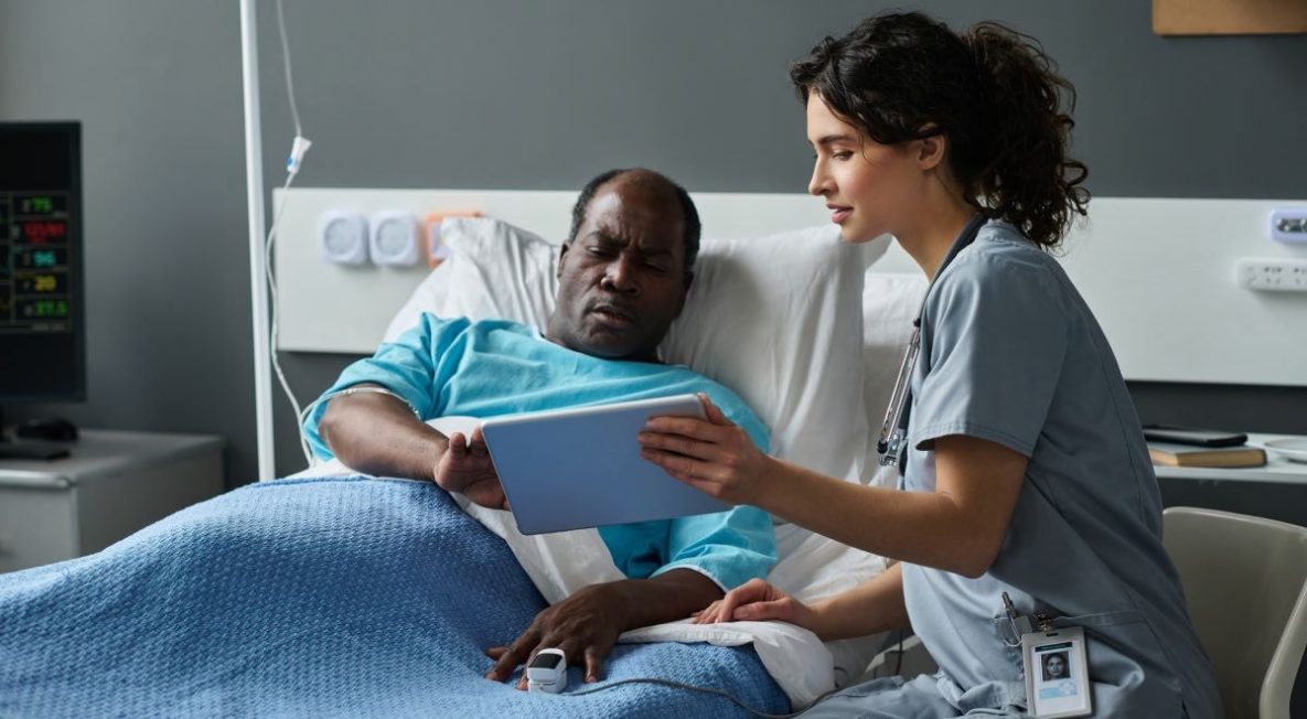 NHSN’s New Approach to Patient Safety and Hospital Data Hospitalize senior man and his female doctor using digital tablet at the clinic.
