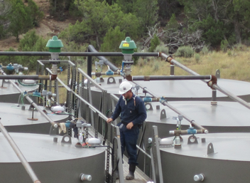 2017-102.png Worker preparing to gauge oil production tanks.