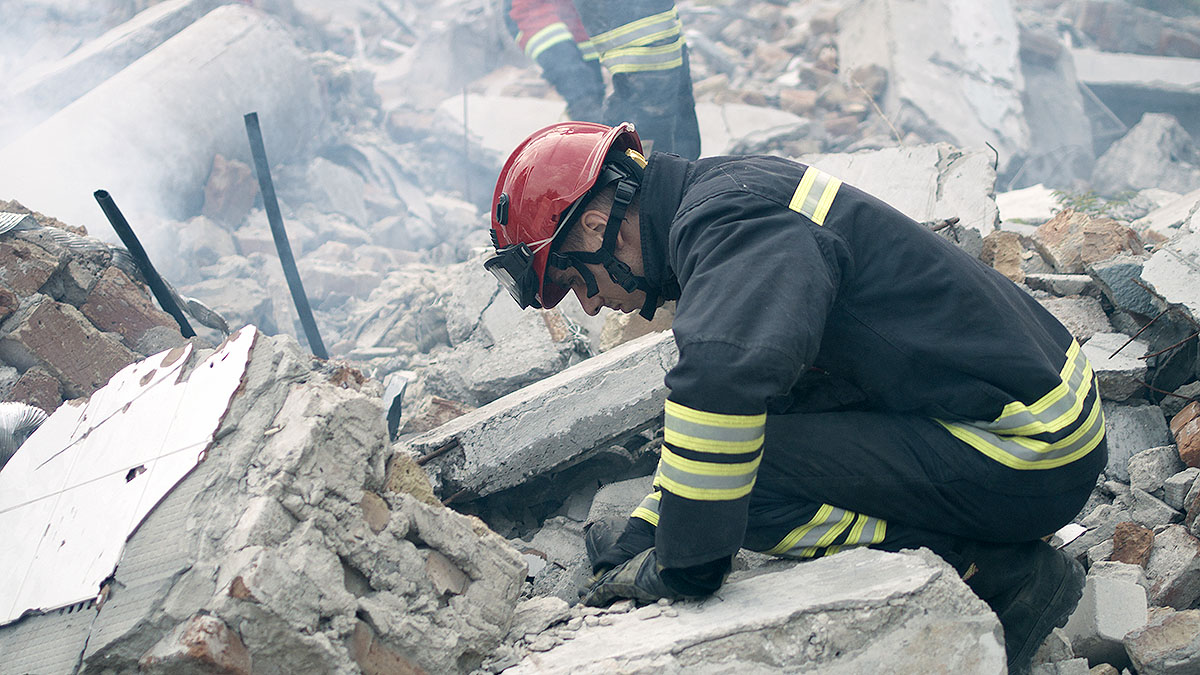 Male rescuers removing concrete rubble Male rescuers removing concrete rubble