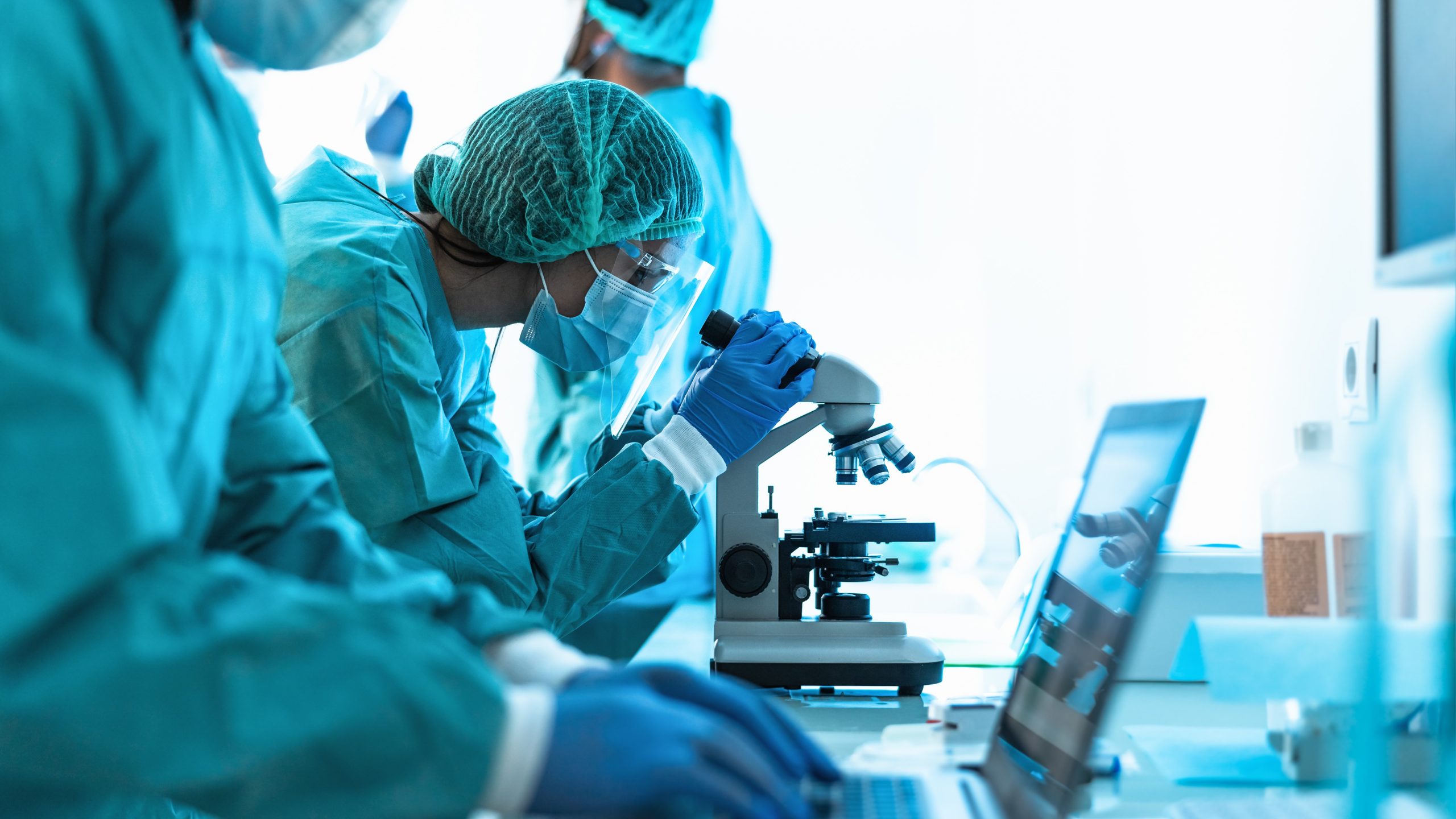 EPRO thumbnail DSRR person wearing protective glasses and clothing looking into a microscope