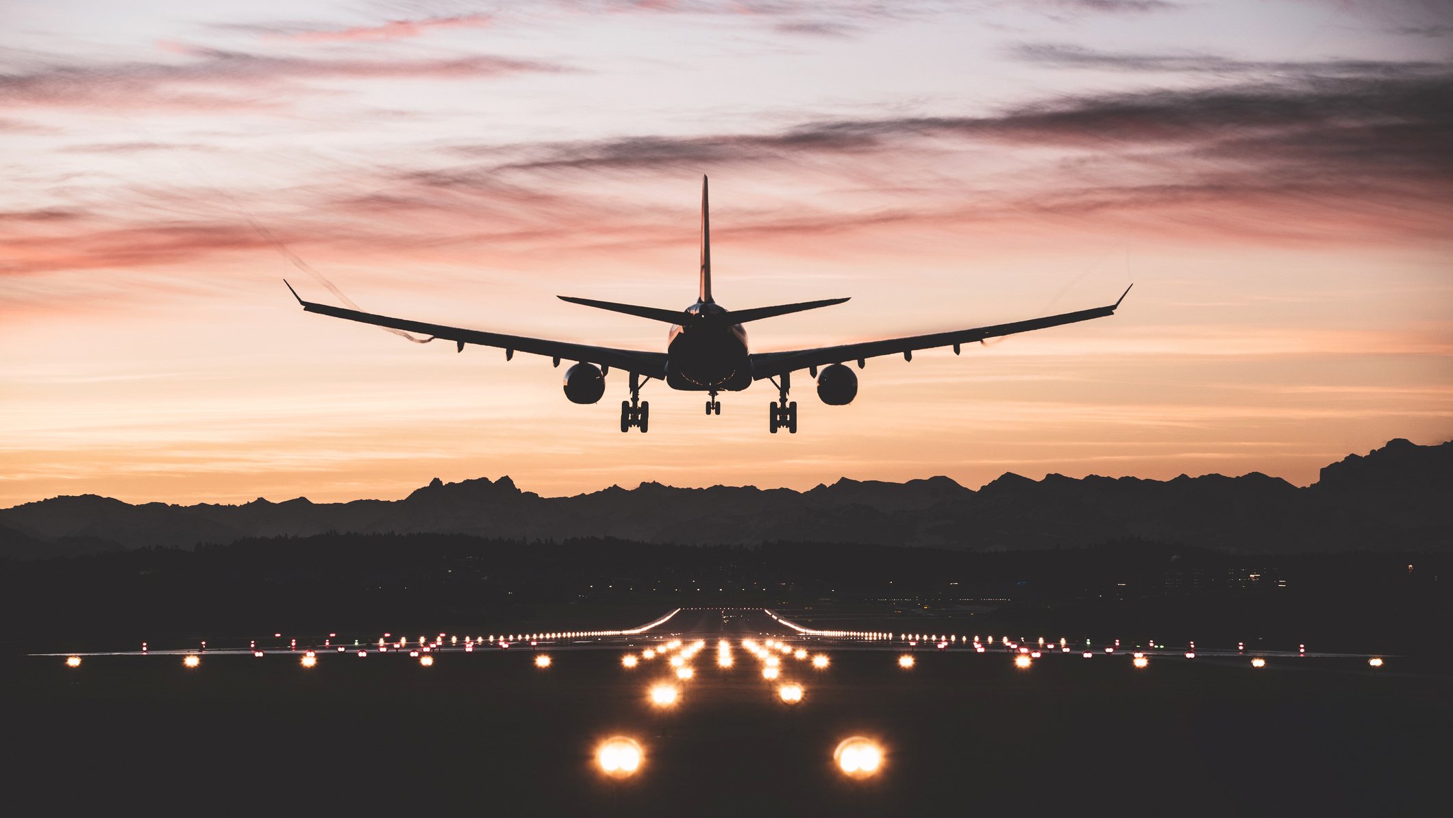 1303030943 A commercial aircraft landing at an airport during dusk.